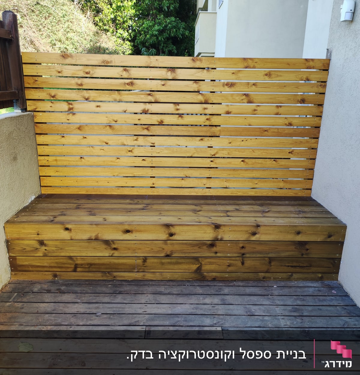 גדר עץ עם ספסל עץ בגינה